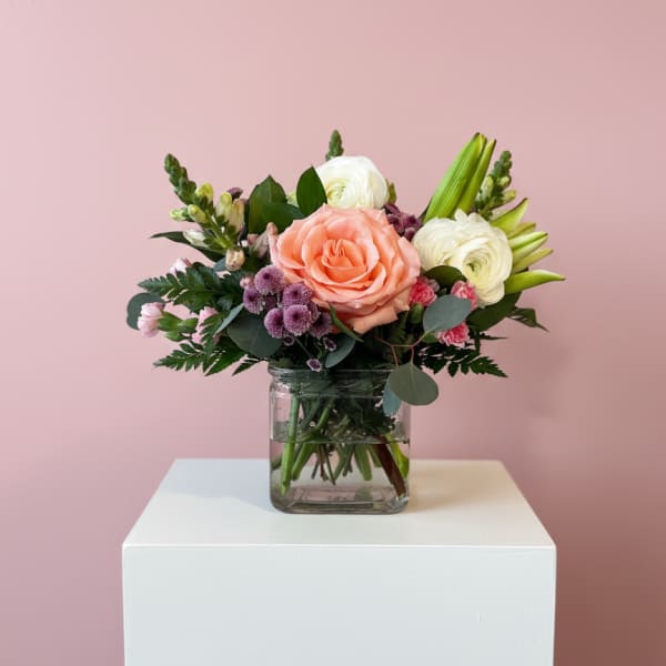 Bouquet of peach and white flowers in a clear glass vase