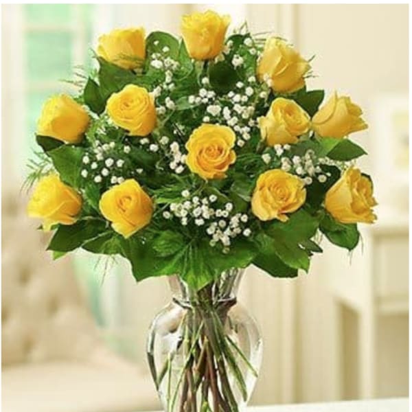 Bouquet of yellow roses with baby's breath in a clear glass vase