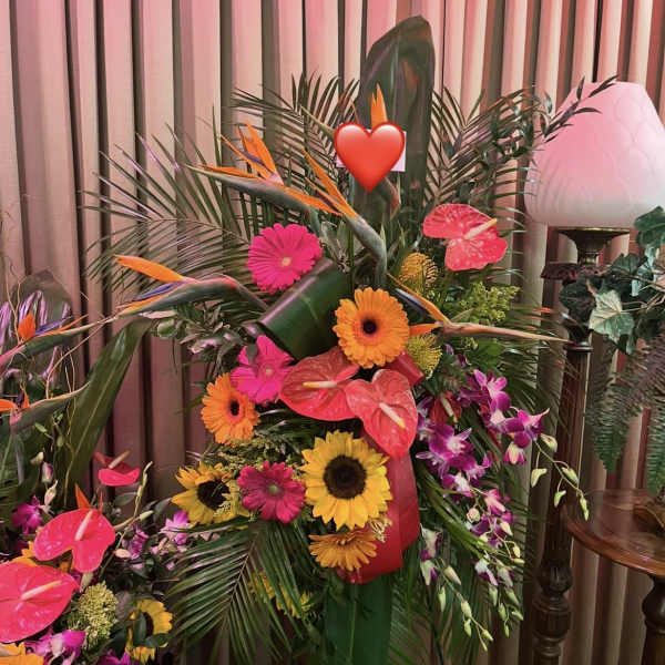 Tropical floral arrangement with sunflowers, gerbera daisies, and pink anthuriums