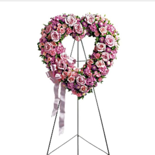 Pink rose funeral wreath on a standing easel with ribbon