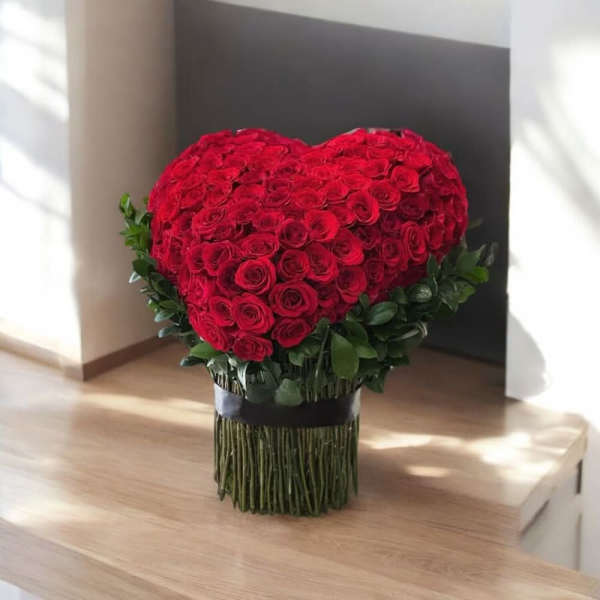 Heart-shaped bouquet of red roses with a dark ribbon wrap