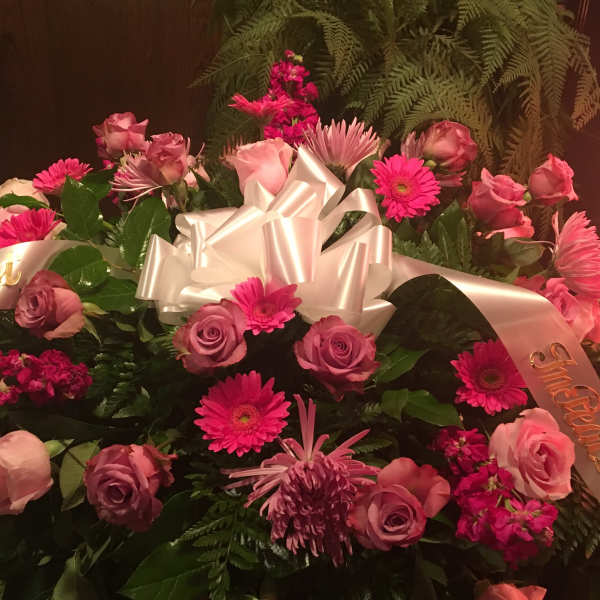 Pink and lavender flower arrangement with a white ribbon bow