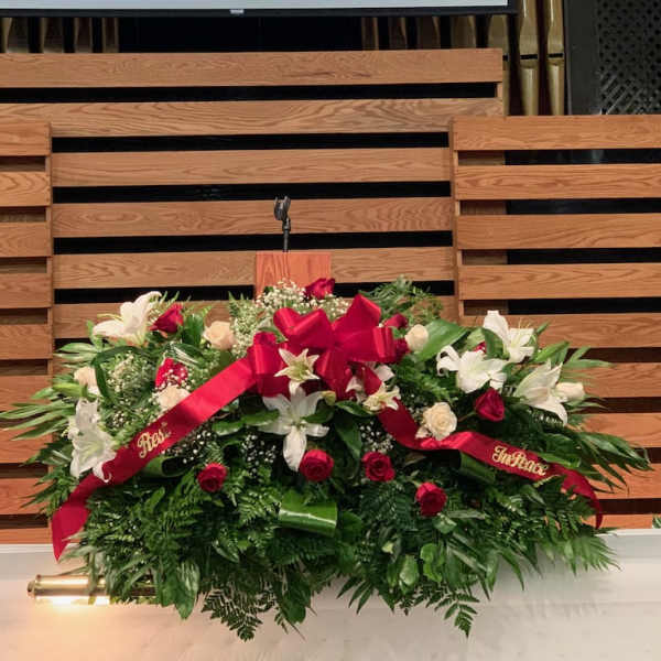 Large floral spray with white lilies and red roses on a stand