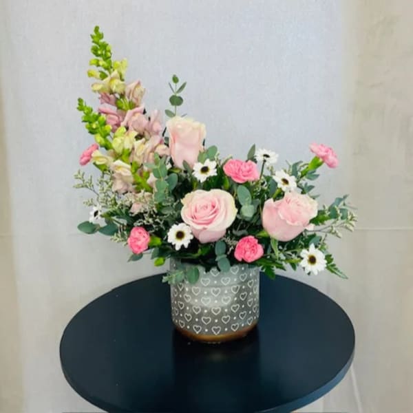 Pink roses and white daisies in a heart-patterned vase