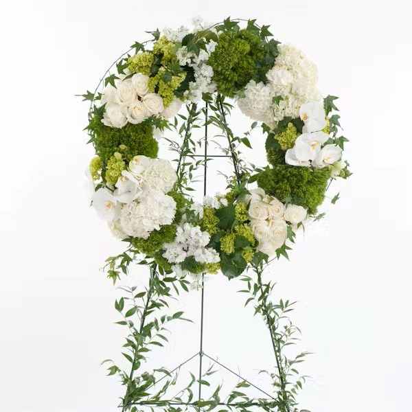 White and green floral wreath on a standing easel