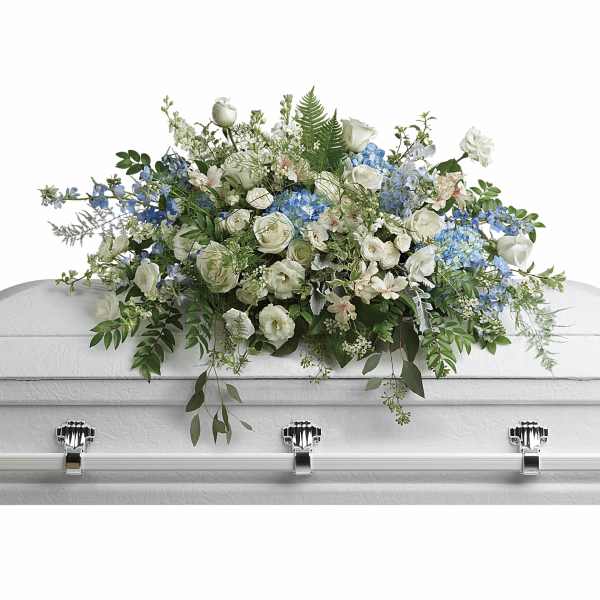White and blue floral casket spray with greenery