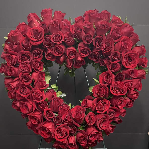 Heart-shaped wreath of red roses on a stand