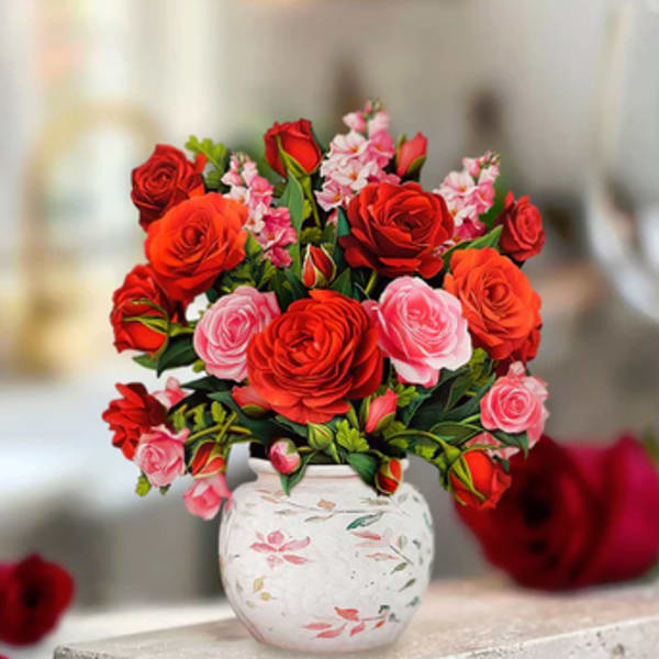 Bouquet of red and pink roses in a white floral vase