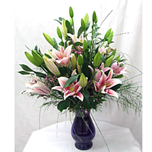 Pink lilies arranged in a dark glass vase