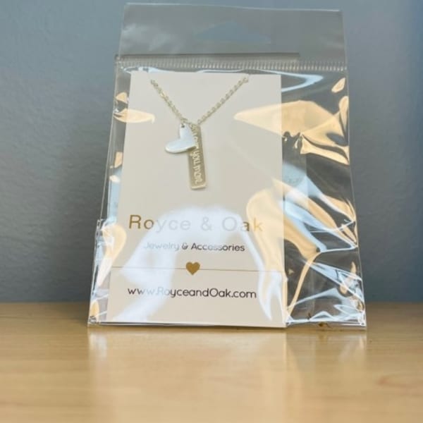 Necklace with heart and bar pendants in a clear plastic pouch