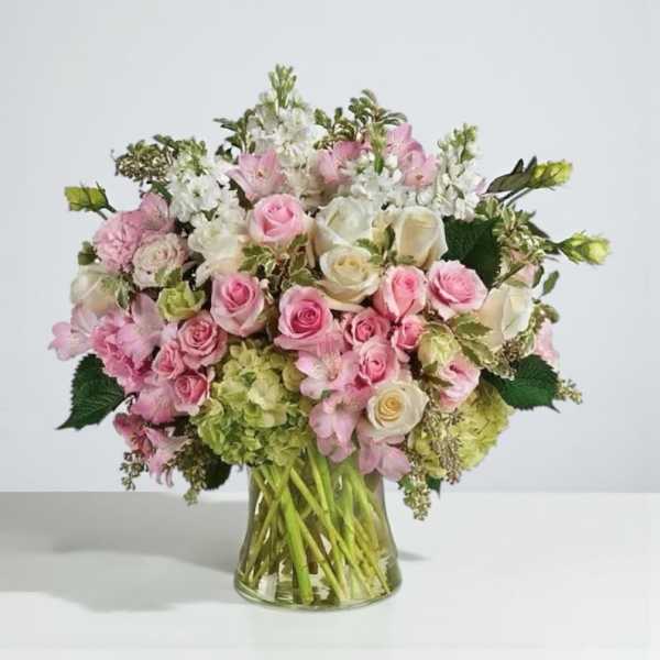 Pink and white rose bouquet in a clear glass vase