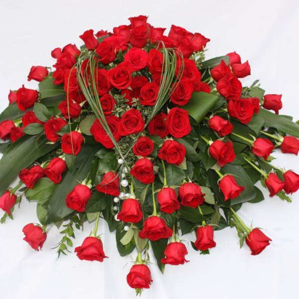 Large bouquet of red roses with greenery on a white background