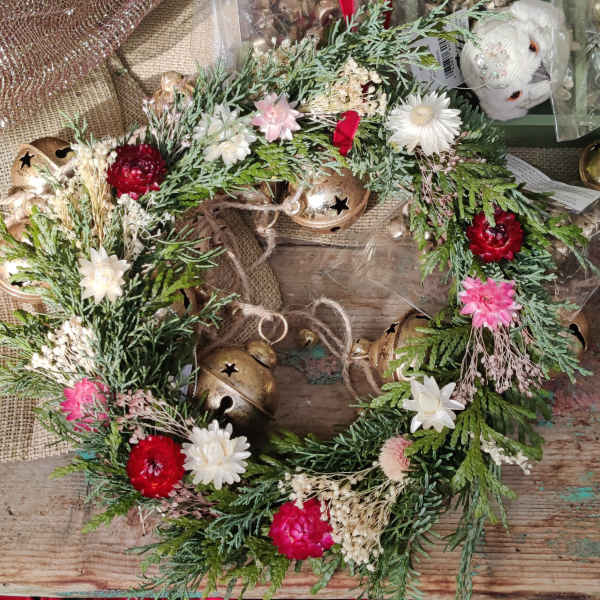 Floral wreath with red, pink, and white blooms and gold bells
