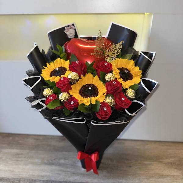 Bouquet of red roses and sunflowers with chocolates and a heart balloon