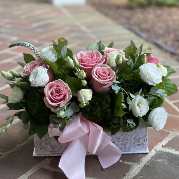 Pink and white roses in a decorative box with a pink ribbon