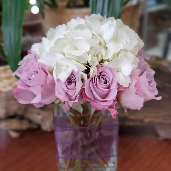 Pink roses and white hydrangeas in a clear square vase