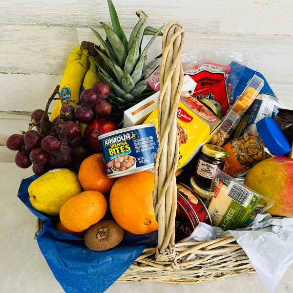 Wicker basket filled with fruit and packaged snacks