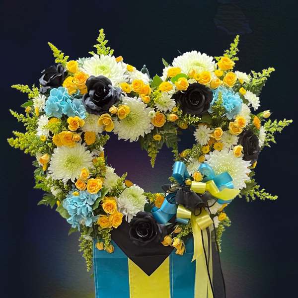 Heart-shaped floral arrangement in a blue and yellow box with ribbons