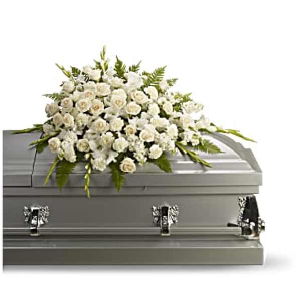 White floral casket spray on a gray casket