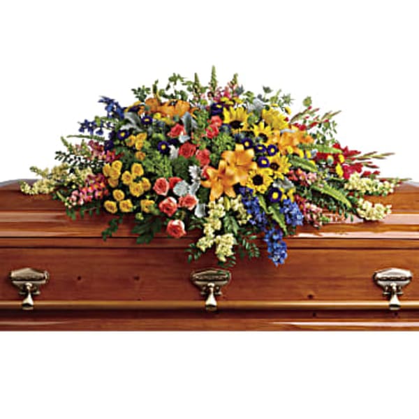 Colorful floral spray arranged on a wooden casket