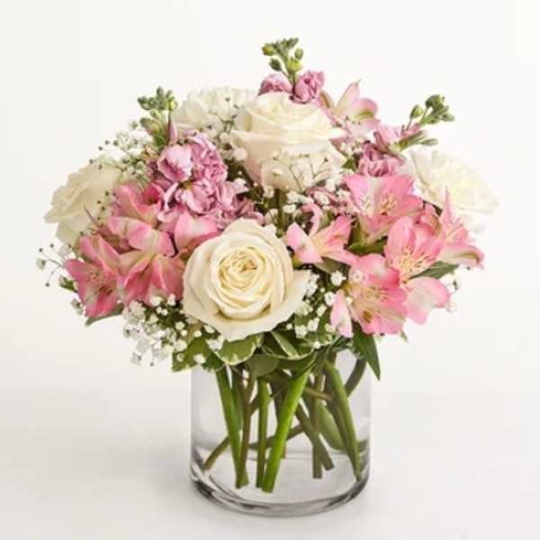 Pink and white bouquet of roses and alstroemeria in a clear glass vase