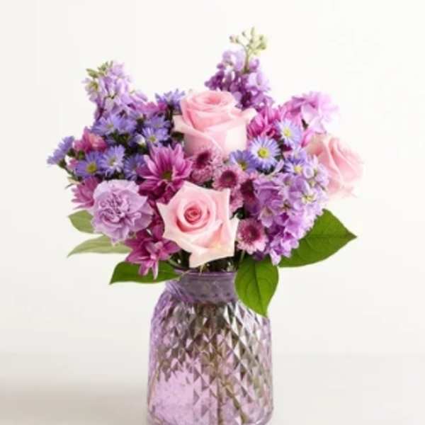 Pink and purple mixed bouquet in a textured glass vase