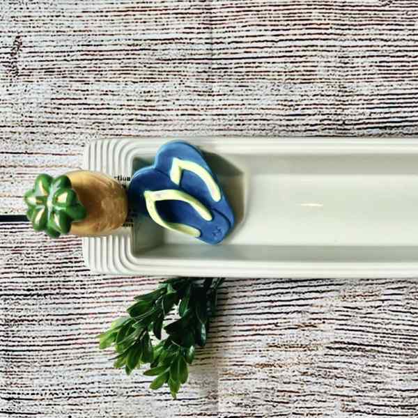 Rectangular white serving tray with a small decorative succulent and flip-flop accents