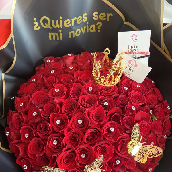 Heart-shaped bouquet of red roses with gold accents and a small crown