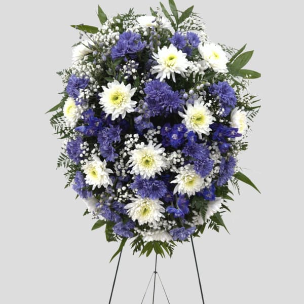 Standing floral wreath of white and purple flowers on an easel