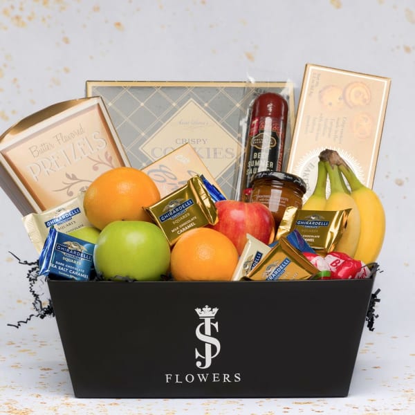 Gift basket with fruit, chocolates, cookies, and a bottle in a black box