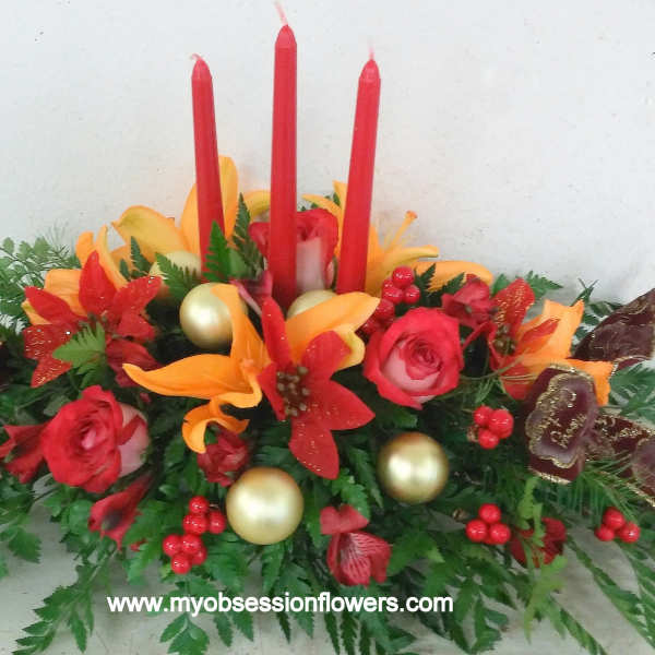 Red and orange floral centerpiece with tall red candles