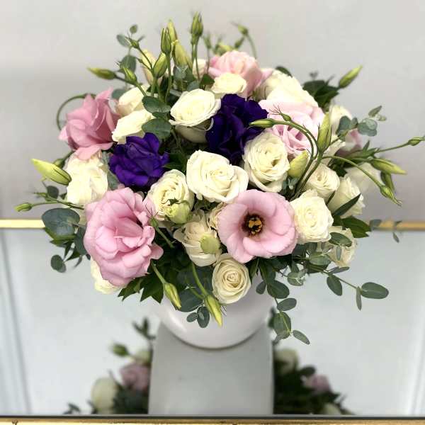 Bouquet of pink, white, and purple flowers in a white vase