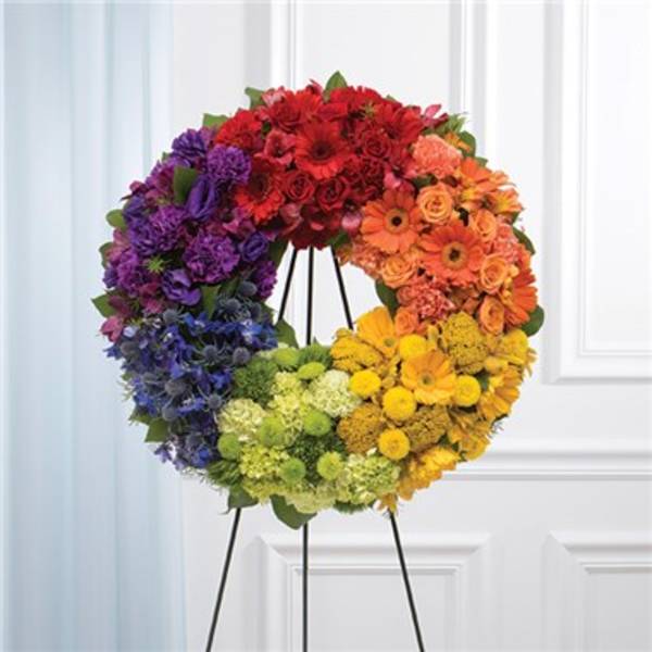 Rainbow floral wreath on a black stand