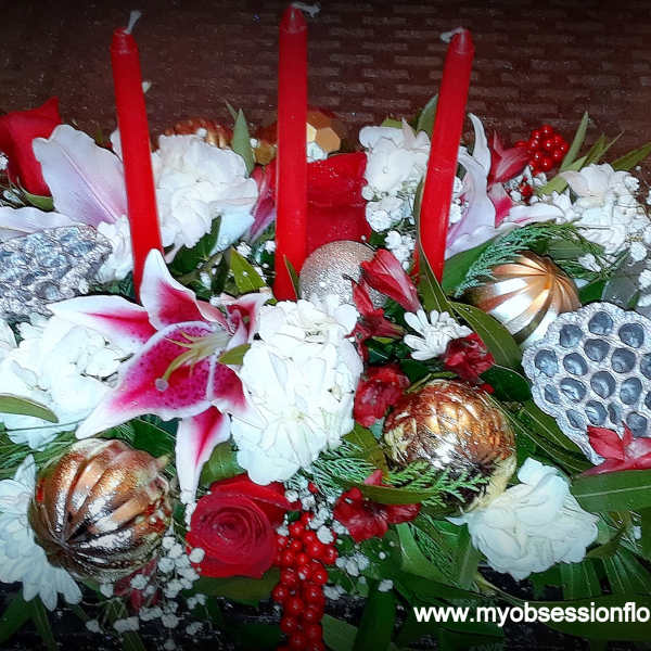 Red and white floral centerpiece with tall red candles