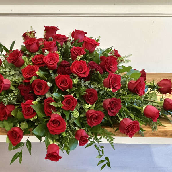 Large arrangement of red roses on a wooden table
