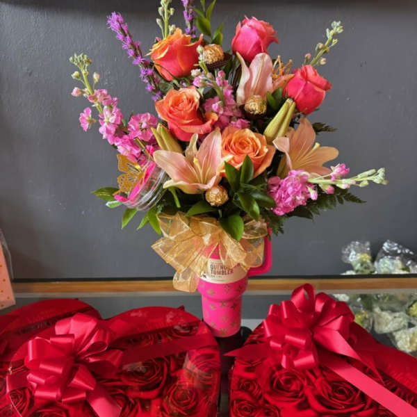 Pink and orange bouquet in a pink tumbler, with heart-shaped rose boxes below.