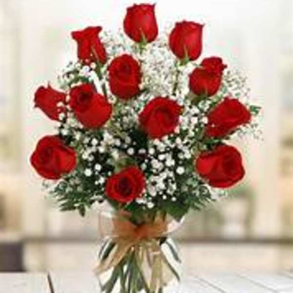 Bouquet of red roses in a clear vase with baby's breath