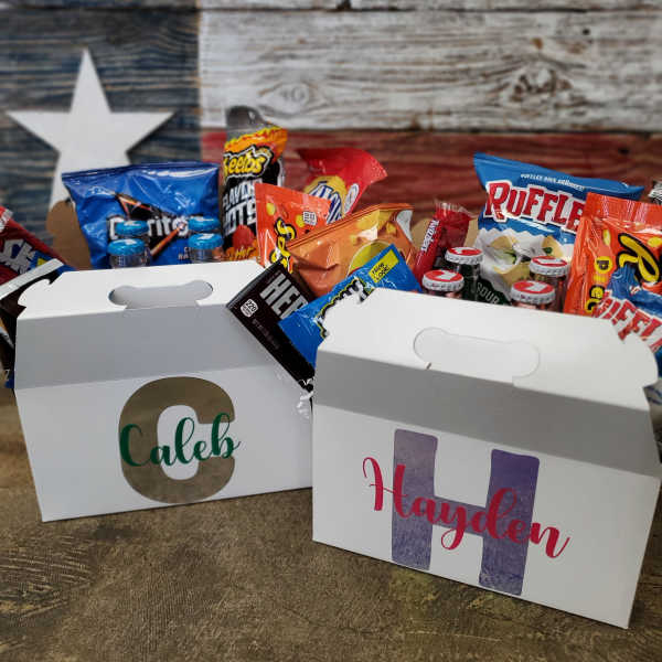 Two personalized snack boxes filled with assorted chips and candy