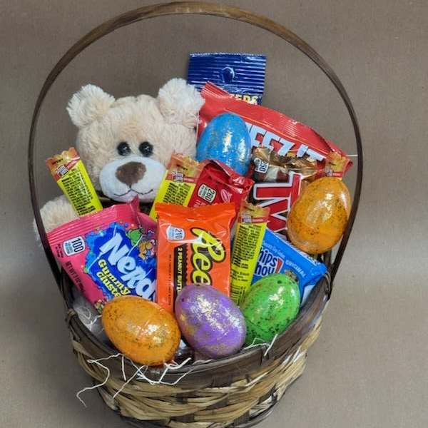 Basket of candy with a teddy bear and colorful Easter eggs