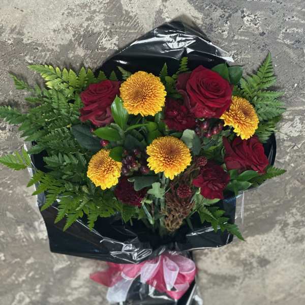 Bouquet of red roses and yellow chrysanthemums wrapped in black paper