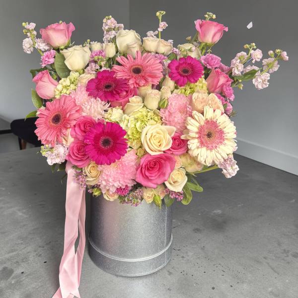 Pink and cream mixed bouquet in a silver hatbox with a pink ribbon