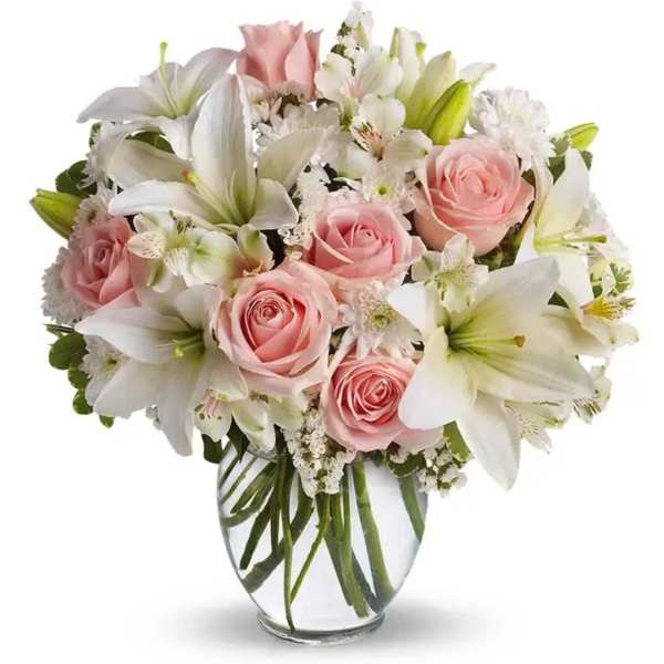 Pink roses and white lilies arranged in a clear glass vase