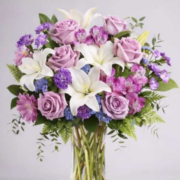 Bouquet of lavender roses and white lilies in a clear glass vase