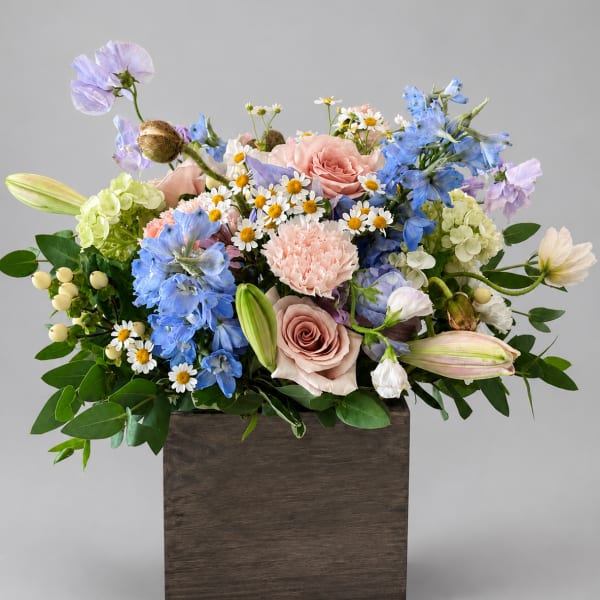 Mixed bouquet of pastel flowers in a wooden box