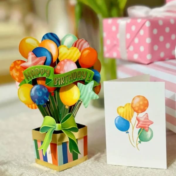 Birthday balloon bouquet in a striped gift box with a greeting card