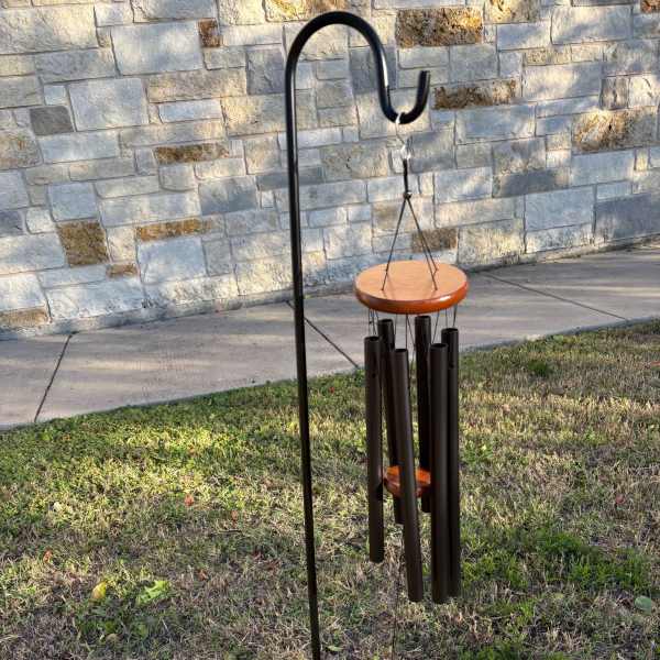 Outdoor wind chime with black tubes and wooden discs