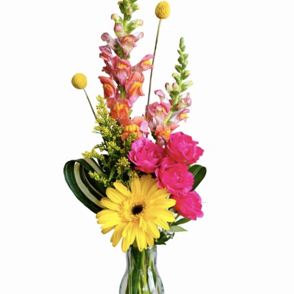 Bright mixed bouquet in a clear glass vase with yellow and pink blooms