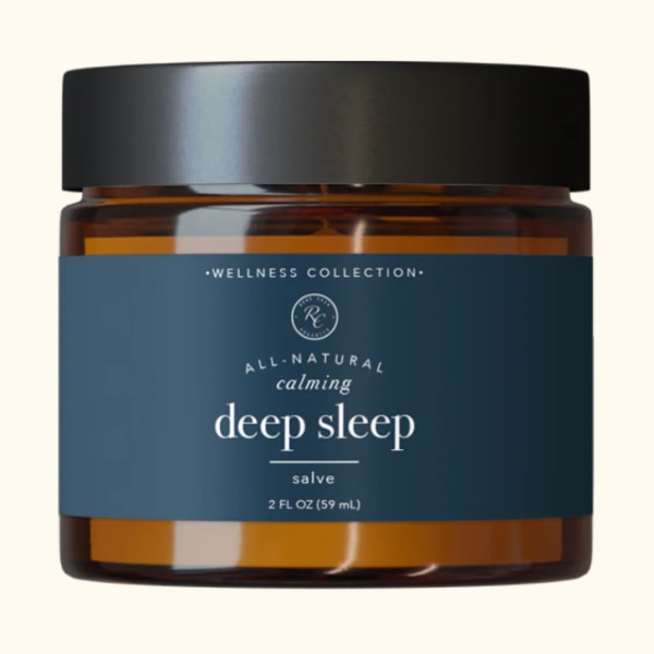 Amber jar of deep sleep salve with a black lid and blue label