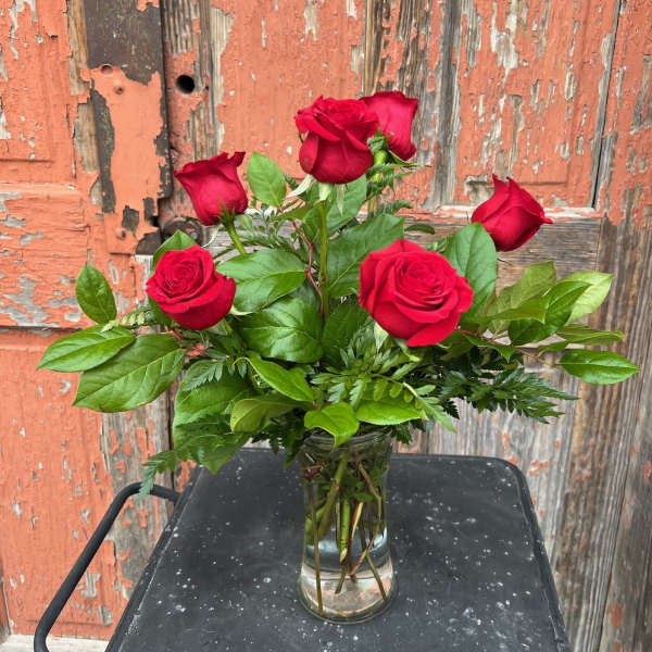 Red roses arranged in a clear glass vase