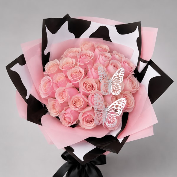 Pink rose bouquet wrapped in pink and black paper with butterfly decorations
